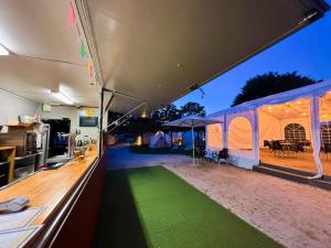 una tienda con un césped verde delante de ella en O Pedrouzo Base Camp, en O Pino  8 fotos más