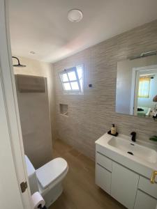 a bathroom with a white toilet and a sink at Alojamientos Vistas Edén 67 in Caleta De Fuste
