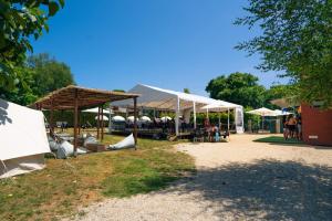 un grupo de sombrillas y mesas en un parque en O Pedrouzo Base Camp, en O Pino 