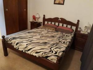 ein Bett mit einer Bettdecke mit Zebramuster in einem Schlafzimmer in der Unterkunft Triplex Oro San Bernardo 2 in San Bernardo