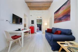 Una sala de estar con un sofá azul y una mesa. en Colosseo Mon Amour, en Roma
