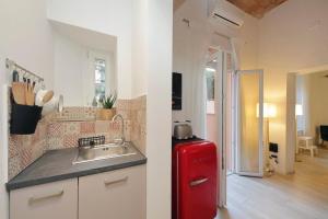 Una cocina con un fregadero y un refrigerador rojo. en Colosseo Mon Amour, en Roma 66 fotos más
