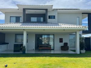 een wit huis met een bank in de voortuin bij Morada de Gaudi in Porto Seguro