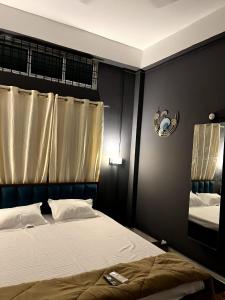 a bedroom with a bed and a mirror on the wall at Midtown Retreat in Dibrugarh