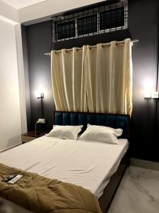 a bedroom with a large bed with a curtain at Midtown Retreat in Dibrugarh