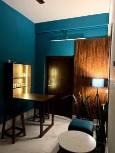 a dining room with a table and a blue wall at Midtown Retreat in Dibrugarh