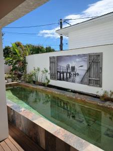 a swimming pool in front of a house with a painting on the wall at La Kazaka Terre Sainte in Saint-Pierre