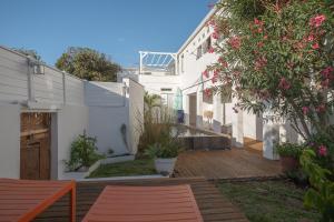 a backyard with a wooden deck and a white house at La Kazaka Terre Sainte in Saint-Pierre