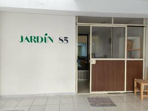 a white building with a sign on the side of it at Jardin 85 Hostel in Morelia