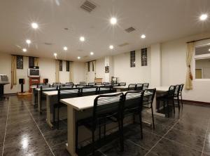 a room with rows of tables and chairs at Hua Xiang Motel - Fengshan in Kaohsiung
