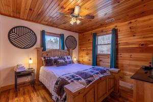 a bedroom with a bed and a ceiling fan at Riverbend Retreat in Todd