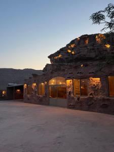 un gran edificio de piedra con muchas ventanas en Adel rum camp bubbles, en Wadi Rum