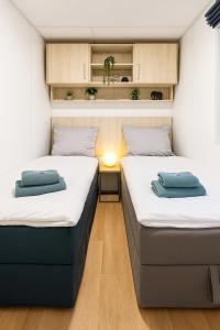 twee bedden in een kleine kamer in een caravan bij Tiny House mit Terrasse und Garten in Altstadtnähe inkl Parkplatz in Weiden