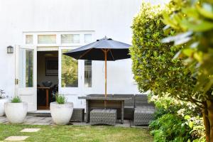 a table with an umbrella on a patio at White Fox House in Burgess Hill
