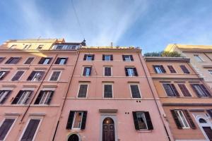 un edificio rosa alto con ventanas en la parte superior en Colosseo Mon Amour, en Roma