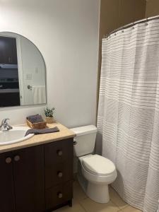 a bathroom with a toilet and a shower curtain at Ski in out au pied des pentes in Bromont