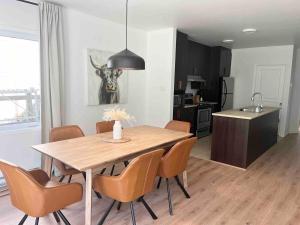a kitchen and dining room with a wooden table and chairs at Ski in out au pied des pentes in Bromont