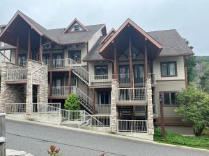 a large house with balconies on the side of the street at Ski in out au pied des pentes in Bromont +13 photos