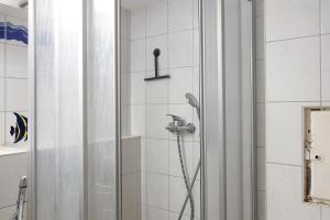 a shower with a shower head in a bathroom at Haus am Ufer in Gaienhofen +21 photos