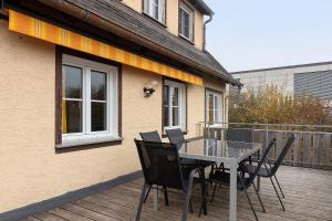 a patio with a table and chairs on a deck at Haus am Ufer in Gaienhofen