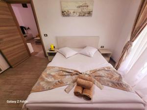 a bedroom with a bed with a bow tie on it at Luxury Beach Resort Apartments Piscina & Spa in Mamaia Nord