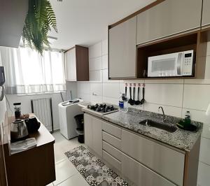 a small kitchen with a sink and a microwave at Rose Prime Loft – Executive Apartment in Extrema in Extrema +21 photos