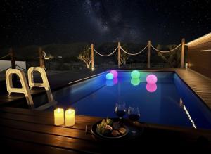 a table with a plate of food next to a swimming pool at night at Zenity Joshua tree in Joshua Tree