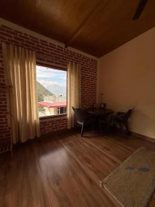 a living room with a table and a large window at Chandra homestay kainchi dham in Rāmgarh +47 photos