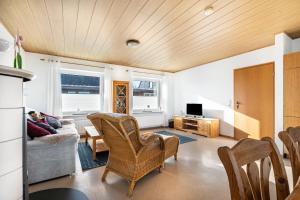 un salon avec un canapé, des chaises et une télévision dans l'établissement Whg 4 - Ferien auf einem Resthof, à Schönhagen