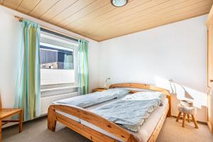 une chambre avec un lit en bois et une fenêtre dans l'établissement Whg 4 - Ferien auf einem Resthof, à Schönhagen