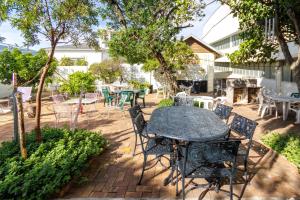a patio with a table and chairs and trees at Elana Beachfront Condo in Strand +16 photos