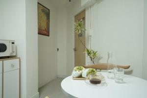 een witte keuken met een tafel met een bord eten bij stay105행궁 in Suwon