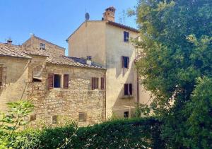 an old stone building with a chimney on top of it at L'Antica Nicchia - Centro Storico in San Gimignano