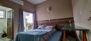 ein Schlafzimmer mit einem Bett und einem Glastisch in der Unterkunft Chalé Vovó Zezé in Bertioga + 41 Fotos