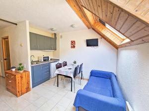 a living room with a blue couch and a table at Apartamentos Solaris 3000 in Pas de la Casa
