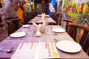 a long table with plates and napkins on it at Hotel BLUE DIAMOND in Begusarai +41 photos