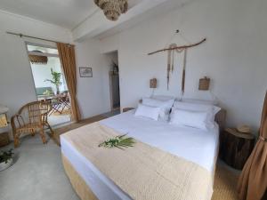 a bedroom with a white bed with a plant on it at Kazalea in Mt Bois Noir