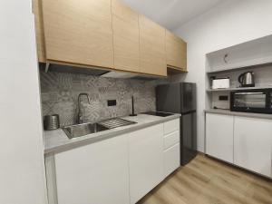 a kitchen with white cabinets and a sink and a refrigerator at casa Mimi in Taggia