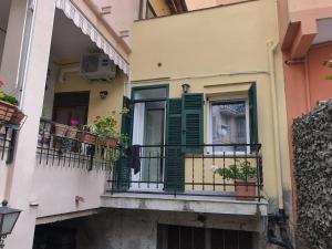 a building with a balcony with green shutters at casa Mimi in Taggia