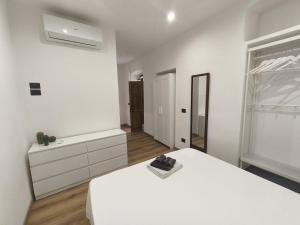 a white bedroom with a white bed and a window at casa Mimi in Taggia