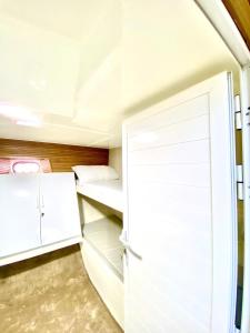 ディバにあるMusandam Starlight Dhow Cruiseのベッド1台とクローゼットが備わる小さな客室です。