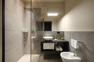 ein Badezimmer mit Waschbecken, Toilette und Dusche in der Unterkunft Hotel Ladurner in Meran