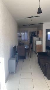 a living room with a couch and a table with a tv at Casa com garagem 4 pessoas in Ponta Grossa +12 photos