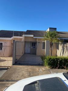 a white car parked in front of a house with a gate at Casa com garagem 4 pessoas in Ponta Grossa