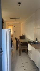 a kitchen with a table and chairs and a refrigerator at Casa com garagem 4 pessoas in Ponta Grossa