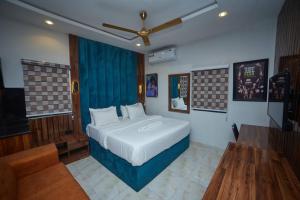a bedroom with a bed and a couch and a television at Masters Class Apartments in Mama