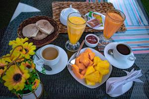a table with cups of coffee and plates of food at Sumaq Wari Hotel in Ayacucho
