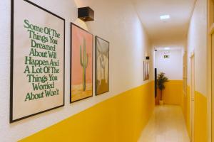 a hallway with paintings on the wall at Casa Antares in Granada