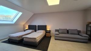 a bedroom with two beds and a couch and a window at Gästehaus Ferienwohnung Zimmer 2C oder Zimmer 2D in Jülich +26 photos