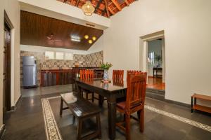 a kitchen and dining room with a wooden table and chairs at The Village Casa in Aldona